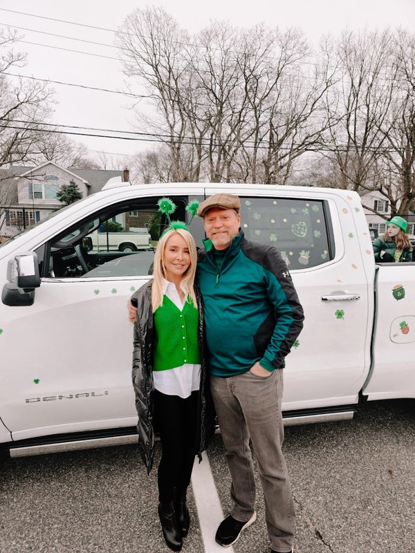 Saint Patrick's Day Parade couple posing in front of truck