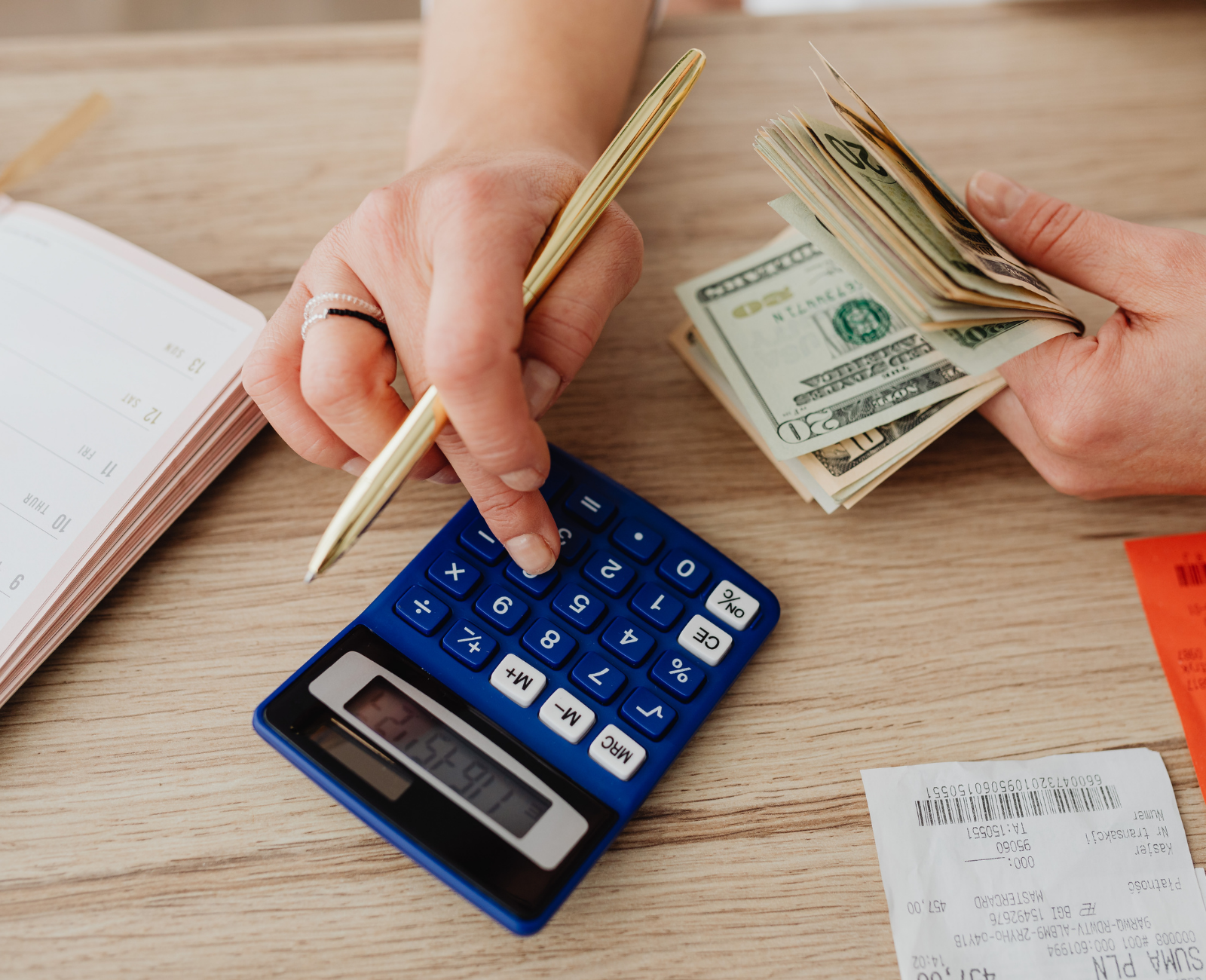 Person calculating total savings with calculator and money